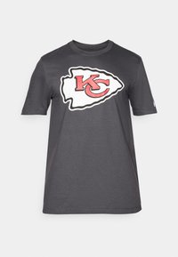 Grå t-shirt med korte ermer, der har et stort hvidt og rødt Kansas City Chiefs-logo i midten, lavet af blødt bomuldsmateriale.