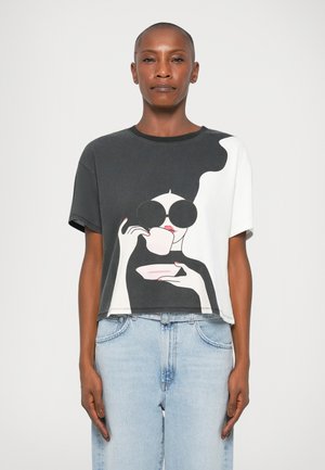 T-shirt cropped em algodão com uma graphic em preto e branco de uma figura com óculos de sol oversized, copo rosa e um decote em contraste.
