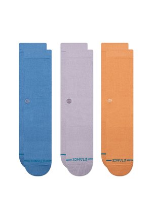 Tres pares de calcetines tipo tripulación en azul, lavanda y naranja. Fabricados con una tela texturizada, presentan un pequeño logo y puños de color contrastante.