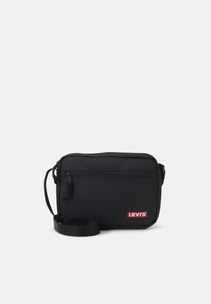 Czarna prostokątna torba na ramię z przednią kieszenią na zamek i czerwoną naszywką z logo Levi's, regulowany pasek na ramię na jednolitym tle.