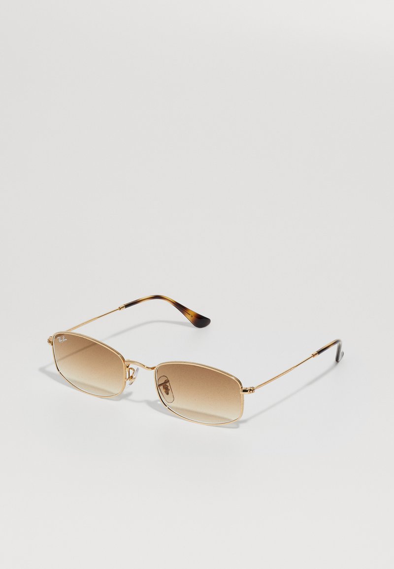 Lunettes de soleil en métal doré avec des montures rectangulaires, des verres bruns dégradés et des accents en écaille sur les branches. Design léger et élégant.