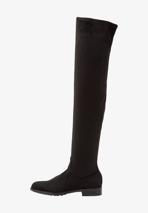 Stivale nero al ginocchio, basso e piatto, con punta rotonda e tacco basso impilato, di texture liscia, esposto su uno sfondo bianco.