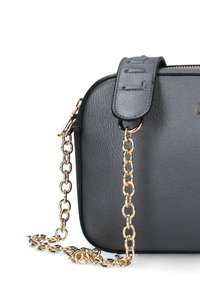 Borsa a spalla in pelle nera con finitura testurizzata, tracolla in catena color oro e dettaglio impresso sul manico superiore. Chiusura con zip.