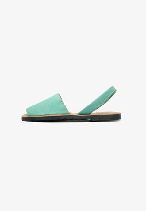 Mint green flat sandals with a soft, textured upper, open strap design, black rubber sole, and a natural beige footbed.