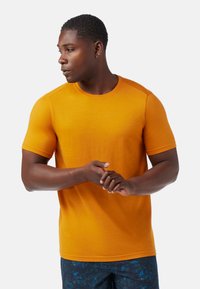 Lyhythihainen crew neck -t-paita kirkkaassa oranssissa, valmistettu tekstuurilla varustetusta kankaasta. Ominaisuuksiin kuuluu istuva malli ja saumatonta olkatietoa.