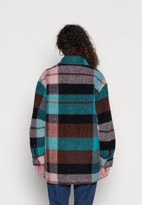 Villakangas ruudullinen takki, jossa on sinisiä, ruskeita ja vaaleanpunaisia värejä, pitkät hihat ja lovettu kaulus, rento malli ja nappikoristeet.