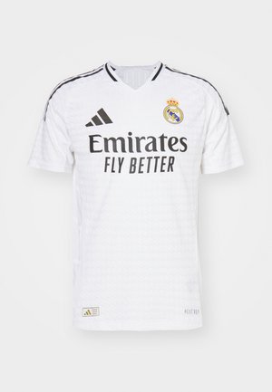 Weißes Fußballtrikot mit V-Ausschnitt, schwarzen Streifenakzenten, "Emirates Fly Better"-Logo, Real Madrid-Wappen und strukturiertem Stoff.