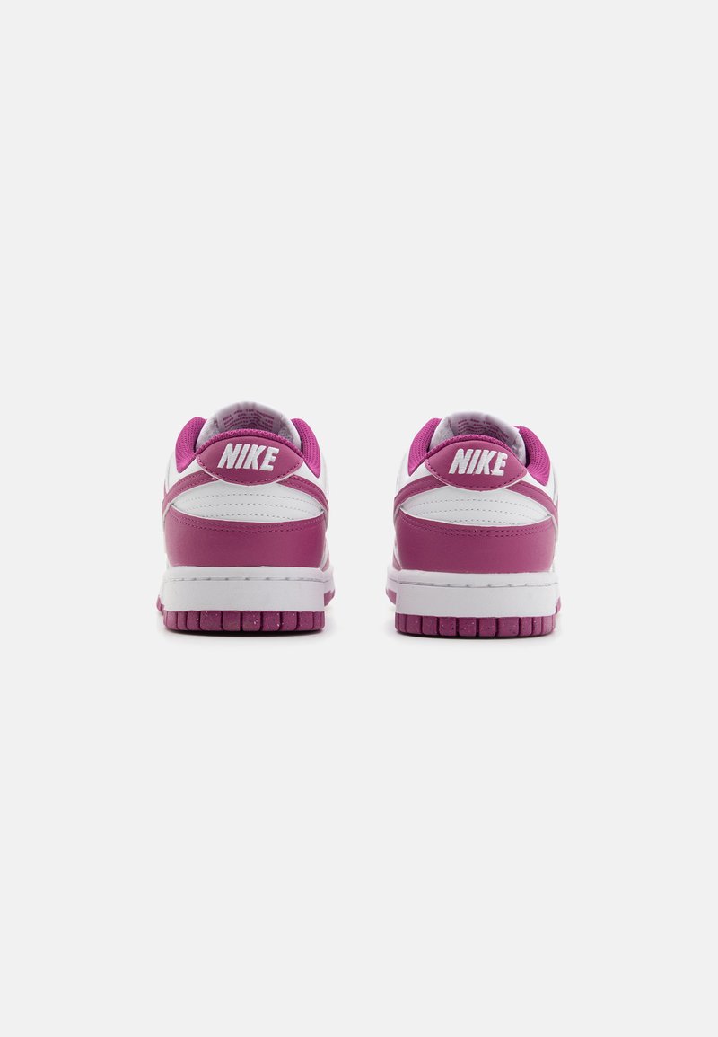 Baskets Nike avec une tige blanche, des accents roses et une semelle en caoutchouc texturée. Les caractéristiques notables incluent un col rembourré et un logo bien en vue.