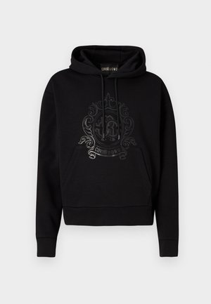 Black hooded sweatshirt featuring a front pocket, drawstrings, and a glossy ornate logo design on the chest. Soft fabric texture.