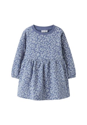 Vestito di cotone blu con maniche lunghe, gonna a pieghe e un motivo floreale bianco su tutta la superficie. Presenta un colletto tondo e una texture morbida.