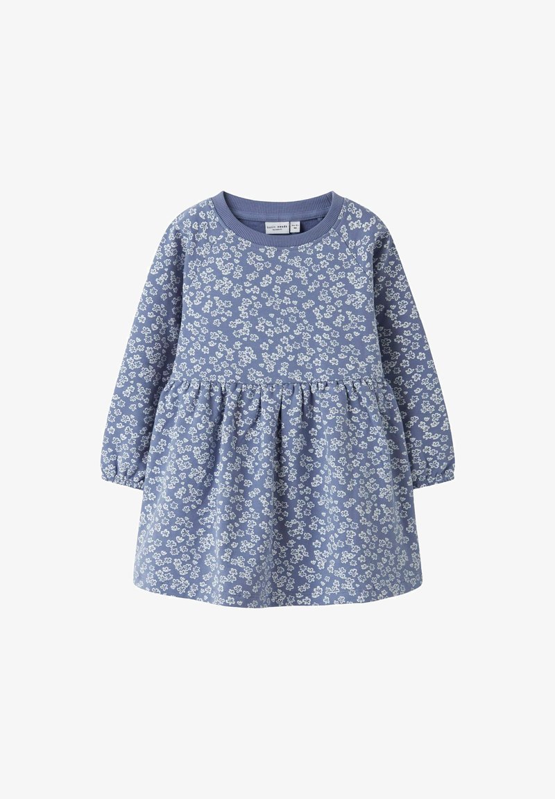 Plava pamučna haljina dugih rukava, s nabranim suknjom i bijelim cvjetnim uzorkom po cijeloj površini. Ima okrugli izrez i meku teksturu.