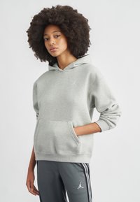 Hall halli kapuutsiga dressipluus kängurutasku ja nööriga kapuutsiga, valge logoga rinnal. Sobitatud hallide triibuliste pükstega.