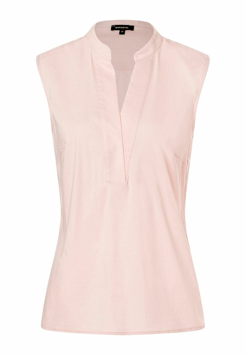 Lys pink udenærmet bluse med ståkrave, der har en V-udskæring og sidelommer, lavet af et glat, blødt materiale.