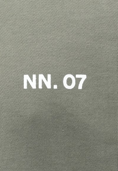 Khaki groene gebreide stof met een geribbeld patroon, met witte bedrukte tekst "NN. 07" centraal geplaatst.