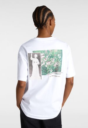 White cotton T-shirt featuring two printed images on the back: a statue and a floral scene, with text incorporated into the design.