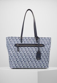 Plátěná taška přes rameno v námořnické modři a bílé barvě s geometrickým vzorem, přední kapsa na zip, dvěmi popruhy a koženou značkovou cedulkou.