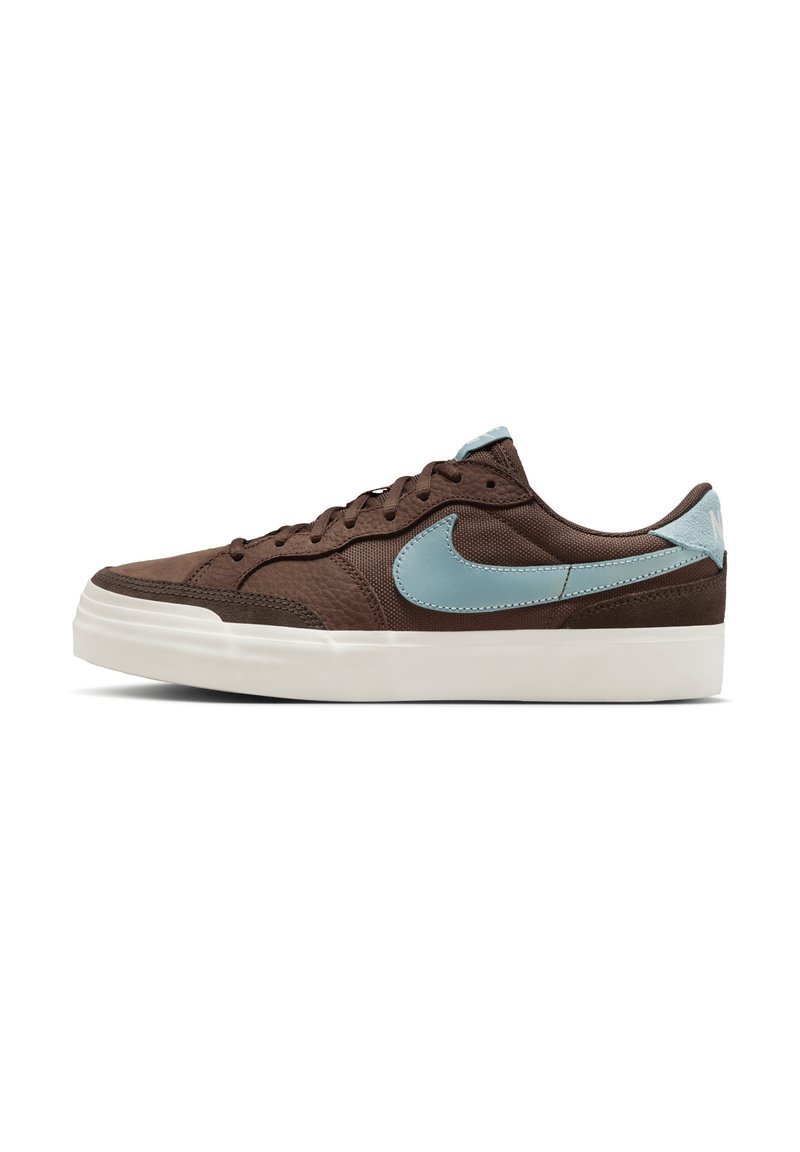 Brun sneaker med tekstureret materiale, lyseblå accenter og hvid gummisål. Har rund tå og flade snørebånd. Side swoosh design.