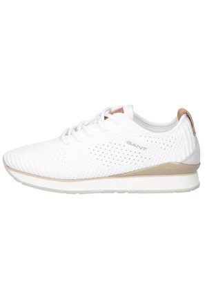 Baskets blanches en maille respirante avec accents beiges, fermeture à lacets et logo de la marque sur le côté et le talon pour un usage décontracté.