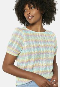 Top multicolore a maniche corte con motivo a zigzag in tonalità pastello, realizzato in materiale knit leggero e con scollatura a girocollo.