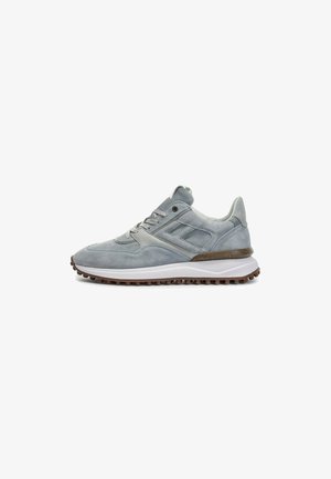 Grijze suède sneaker met een ronde neus, vetersluiting en rubberen zool. Bevat subtiele textuur en een bruin accent op de tussenzool.