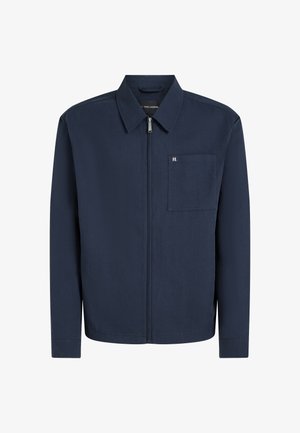 Mørkeblå lynlåstrøje med krave, brystlomme og diskret logodetalje. Fremstillet af glat stof med en struktureret pasform.