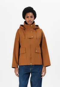 Veste à capuche marron avec fermeture éclair à l'avant, boutons-pression et deux poches avant. Présente une coupe décontractée et un tissu lisse et durable.