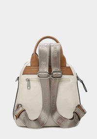 Mochila blanca con acentos de cuero marrón, doble correa plateada y un bolsillo con cremallera. Textura suave, forma rectangular, correas ajustables.