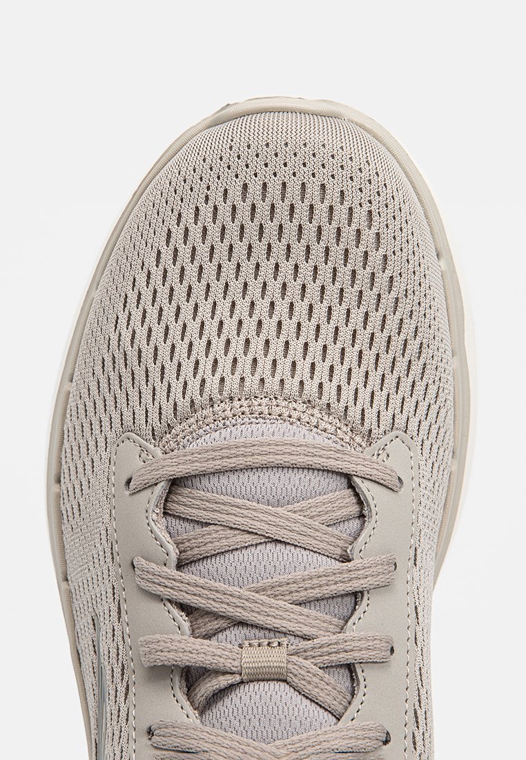 Hellgraue Sportschuh mit einem Mesh-Obermaterial, strukturiertem Schnürbereich und Gummisohle. Verfügt über eine abgerundete Zehenpartie und verstärkte Nähte.