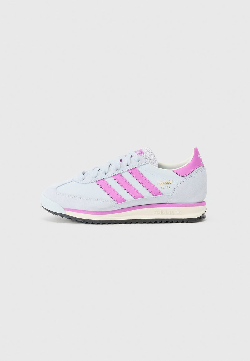 Svetlo modri semiš teniski čevlji s rožnatimi akcenti, z značilnimi tremi črtami, teksturiranim petnim delom in belim podplatom. Retro slog z ravnim, teksturiranim dnom.