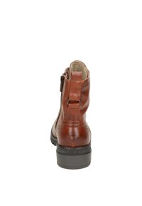 Bottine en cuir marron avec une finition lisse, semelle en caoutchouc noir et fermeture éclair sur le côté. Dispose d'une tirette à l'arrière pour un enfilage facile.