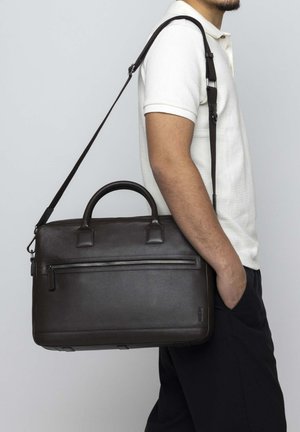 Brown leather laptop bag with dual top handles, a removable shoulder strap, and a front zipper pocket. Smooth texture, rectangular shape.