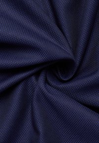 Marineblauer Stoff mit einer strukturierten, quadratischen Musteroberfläche. Der Stoff fühlt sich glatt und leicht glänzend an, was eine reiche visuelle Tiefe erzeugt.