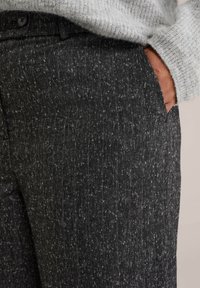 Grau karo gemusterte Hosen aus strukturiertem Stoff, mit einer seitlichen Tasche und einem Knopfbund, im lässigen Schnitt.