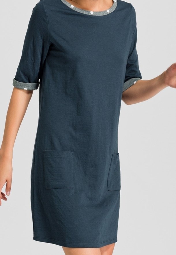 Robe T-shirt bleu marine en tissu doux, avec des manches roulées ornées de pois et deux poches plaquées à l'avant.