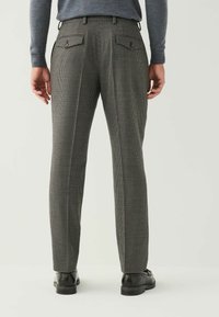 Gray checked trousers with a tailored fit, featuring back pockets and a smooth texture, paired with black dress shoes.