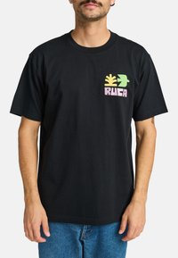 Zwarte katoenen T-shirt met korte mouwen, voorzien van een kleurrijk grafisch ontwerp op de linkerkant van de borst, inclusief blad- en vogelmotieven.
