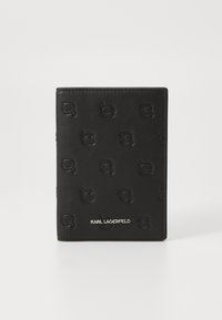 Juodas odinis piniginė su išgaubtu Karl Lagerfeld logotipo raštu, lygaus paviršiaus ir metaliniu prekės pavadinimu apačioje.