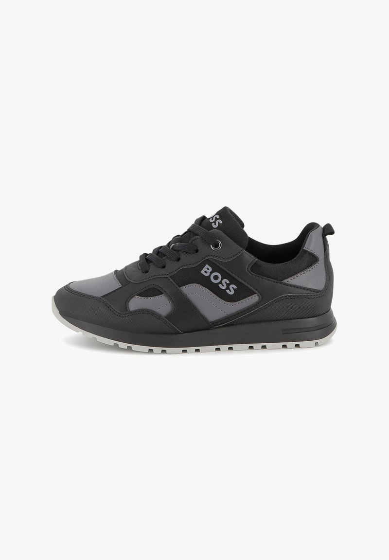 Chaussure de sport noire et grise avec tige en synthétique, panneaux texturés, design à lacets et logo sur le côté, dotée d'une semelle externe en caoutchouc.