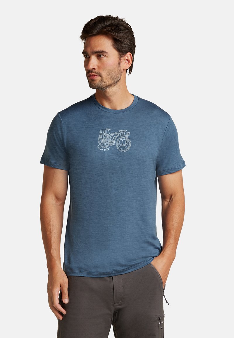 Sininen lyhythihainen t-paita pehmeää kangasta, jossa on valkoinen pyöräkuvio edessä ja pyöreä kaula-aukko.