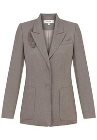 Šedé sako na míru s texturovaným vzorem, zapínáním na jeden knoflík, dvěma předními kapsami a detailní kostkovanou broží na klopě.