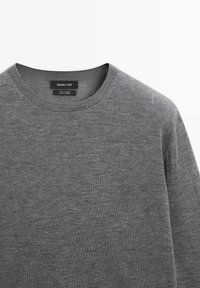 Maglione grigio con scollatura rotonda e texture liscia. L'etichetta sulla scollatura recita "Massimo Dutti." Design semplice senza motivi.