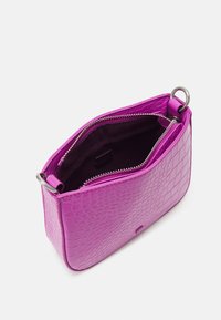 Petit sac à main en simili-crocodile violet avec des anneaux en argent et un compartiment zippé ouvert révélant une doublure intérieure sombre.