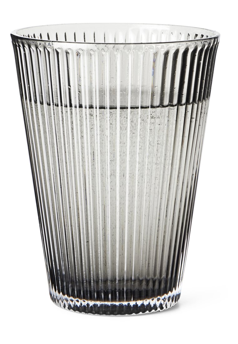 Klarer, gerippter Glastumpler mit einer strukturierten Oberfläche, der zur Basis hin verjüngt ist. Enthält eine kleine Menge Wasser am Boden.