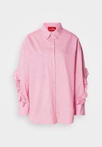 Chemise à manches longues à fines rayures roses et blanches, avec des boutons sur le devant, une poche poitrine à rayures diagonales et des détails à volants sur les manches.