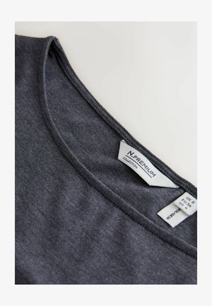Tumši pelēka t-krekls ar apaļu kakla izgriezumu un gludu faktūru. Etiķete iekšpusē rāda zīmola nosaukumu un izmēra informāciju.