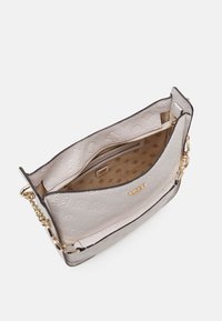 Borsa a spalla in pelle grigia chiara con motivo embossato, hardware dorato e scomparto con zip. L'interno presenta una fodera beige e tasche aggiuntive.