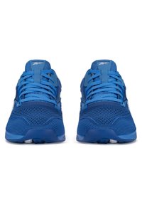 Zili sporta apavi ir ar elpojošu sieta augšdaļu, kas dekorēta ar teksturētām rakstām, kontrastējošām akcentiem, plakanajām šņorēm un mīkstinātām zolemi.