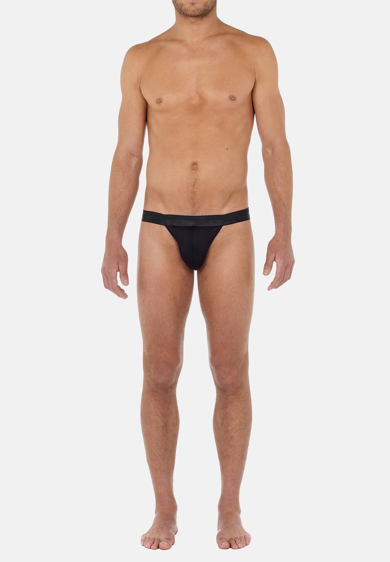 Slip da uomo nero con una texture liscia, vita elasticizzata e copertura minima, caratterizzato da un colore uniforme e un design semplice.