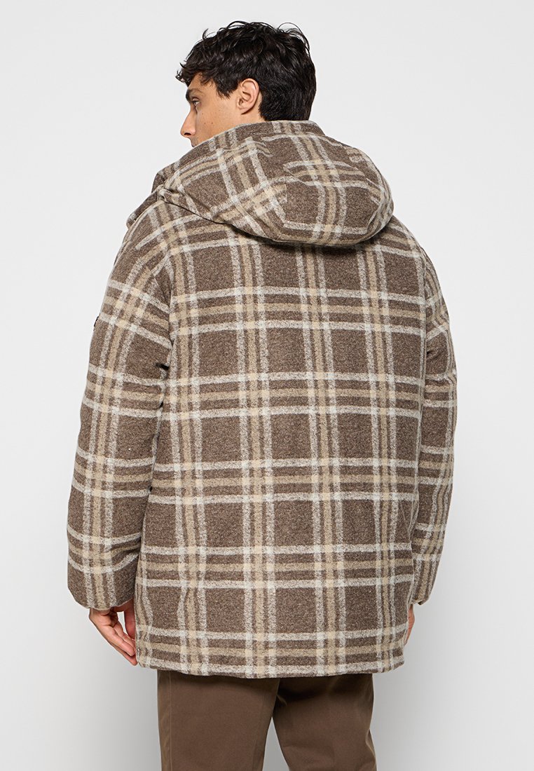 Manteau à carreaux marron avec capuche, en tissu texturé, avec des lignes crème bien marquées et une coupe décontractée, adapté pour un usage quotidien.