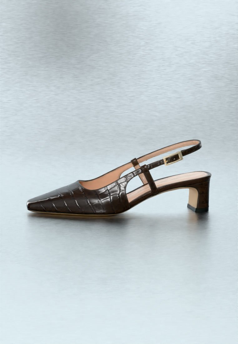 Escarpin slingback marron foncé à texture crocodile, avec bout pointu, petit talon carré et boucle dorée, présenté sur une surface claire.